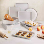 Silver anodized baking tray with raised sides, holding sliced pastries and a loaf